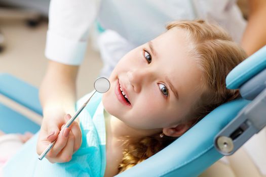 Little girl sitting in the dentists office