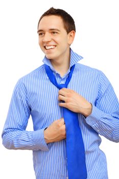 Attractive young business man binding his blue tie