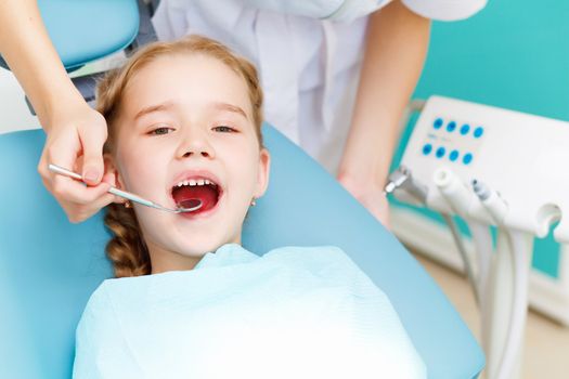 Little girl sitting in the dentists office