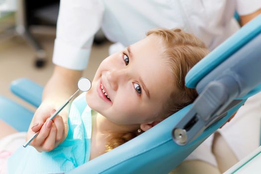 Little girl sitting in the dentists office