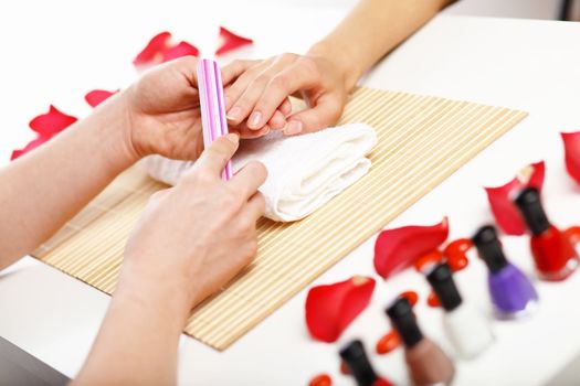 Young woman is getting manicure in a beauty salon