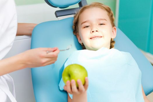 Little girl sitting in the dentists office