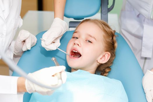 Little girl sitting in the dentists office