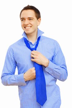 Young businessman at home preparing for a work and making his tie
