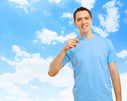 Young man in blue shirt brushing his teeth