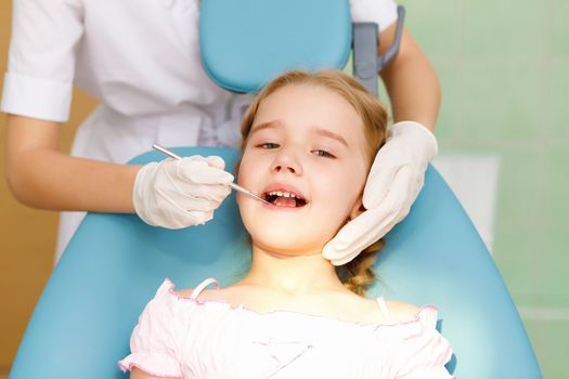 Little girl sitting in the dentists office