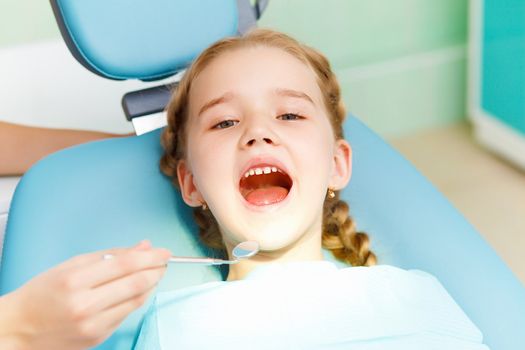 Little girl sitting in the dentists office