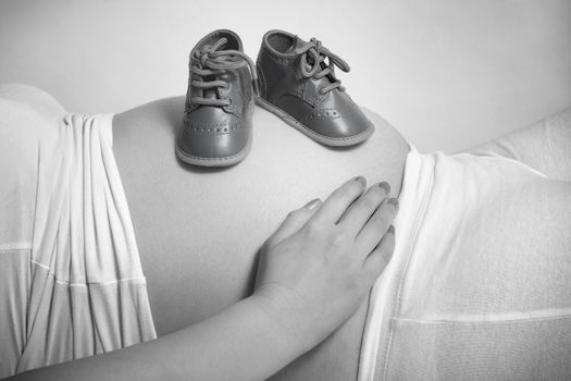 Baby boy shoes on mummy stomach
