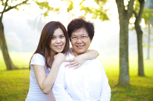 Happy Asian senior mother with her daughter at outdoor park