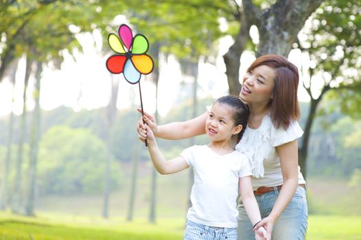 Asian family playing windmill at outdoor park