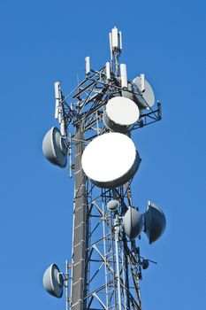 close up of a telecommunications tower against a blue sky