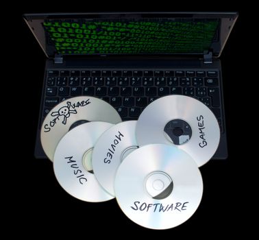 Piracy Concept - Burnt CDs With Illegal Software on Keyboard of Notebook - Isolated on Black Background