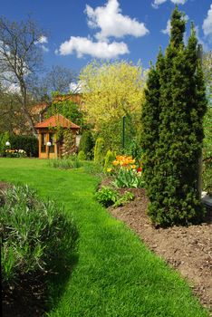 Beautiful spring garden with gazebo and blue sky