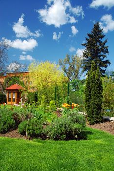 Beautiful spring garden with gazebo and blue sky