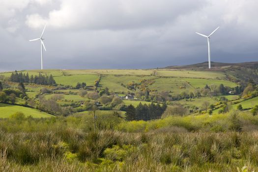 windmills on the hills of Glenough in county Tipperary Ireland with trees and fields in foreground