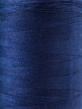 Macro view of blue thread wound on a spool