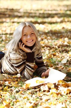 woman read the book in autumn park