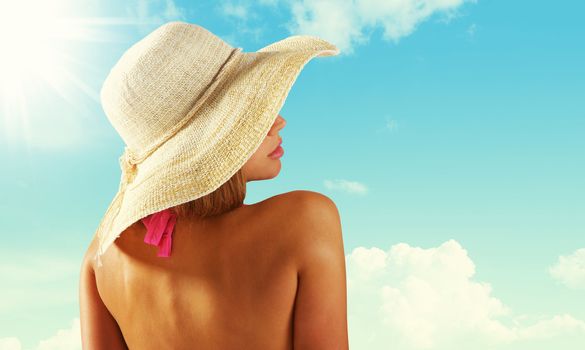 Fashionable woman with straw hat protects from sun