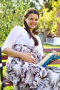 Beautiful female model smiling happy touching her big pregnant belly