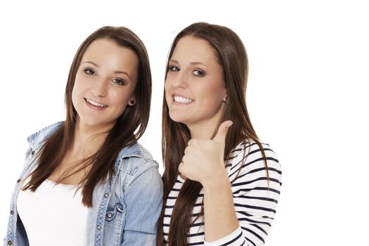 two happy teenager showing thumbs up on white background