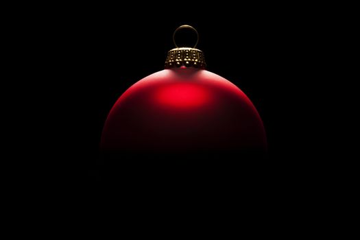 red christmas ball in tense light on black background