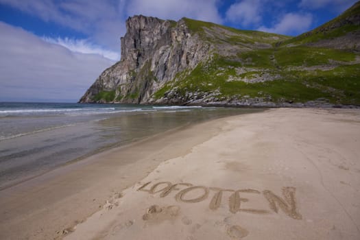 Picturesque beach on Lofoten islands in Norway with word "Lofoten" written in the sand