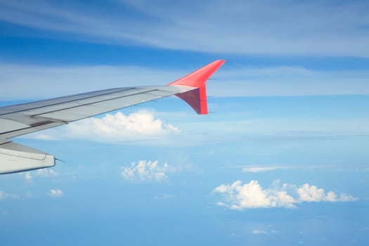Aircraft wing against bluesky from its windows