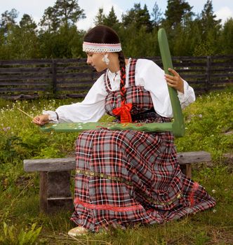 
Girl in national costume Pomeranian paints distaff
