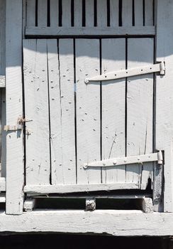 Antique wooden barn door painted white and worn and rotted