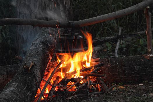 The hunting bonfire with the kettle suspended above him