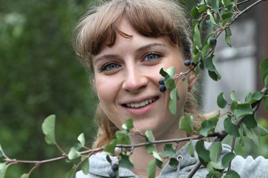 young girl in a garden with a branch berry

