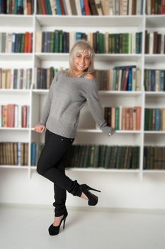 beautiful woman standing at bookshelf