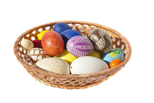 Painted Easter eggs in wicker dish. Festive table decoration.