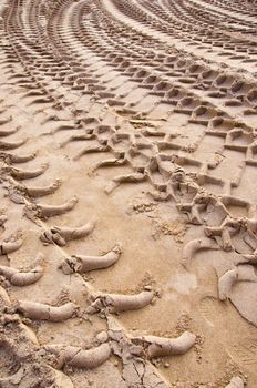 Background mark of truck wheels in sand pit closeup and human footprints.