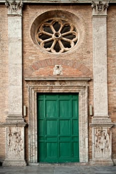 Old roman facade with green door taken in rome