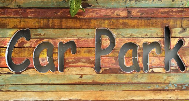 Text "Car Park" engraved on the wood sign