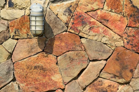 Old white Lamp on the wall made ​​of red stone