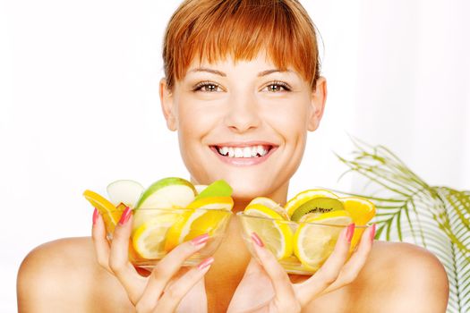 Portrait of a smiled girl with two bowl full of fruit in her hands