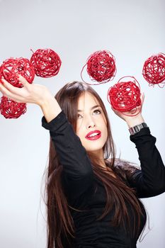 Pretty brunette woman holding red balls