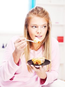 Blond woman eating cake at home