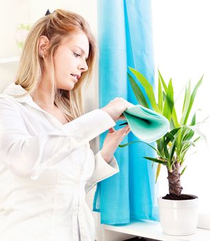 Blond woman clean leafs at home