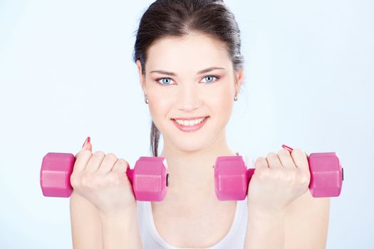 Young woman with two weights doing fitness exercises