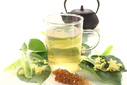 hot lime blossom tea with flowers and leaves on a light background