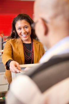 Passing over credit card to shop assistant after shopping