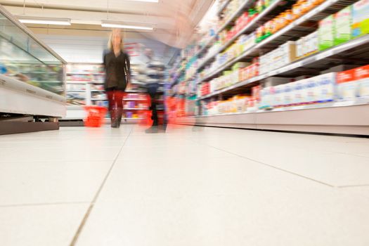 Blurred view of people in supermarket while shopping