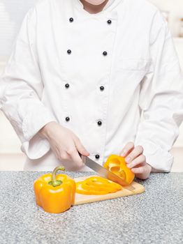 chef cutting bell peppers on board
