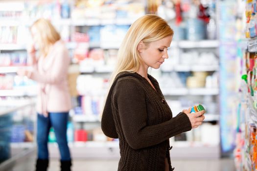 Young woman shopping in the supermarket with people in the background