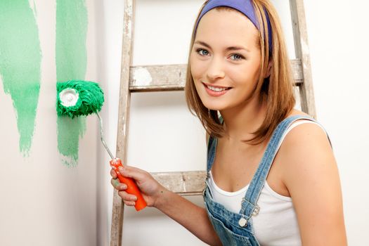 A woman with a roller brush, paiting the wall doing home improvements