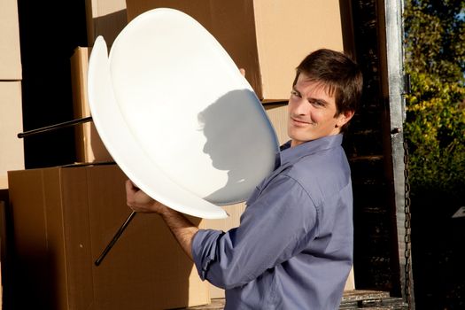 Portrait of a professional mover lifting a chair from a moving truck