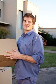 Portrait of a serious man outdoors with cardboard moving boxes